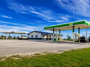 Gas station with two vehicles parked under a blue sky