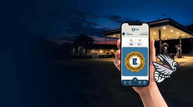 Person holding a smartphone displaying a gas station app