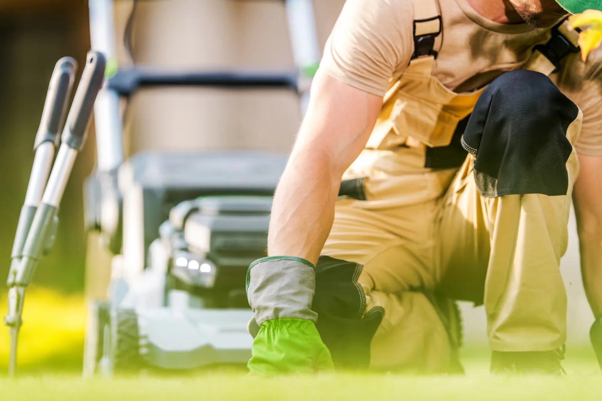 Gardener kneeling on the lawn working with tools