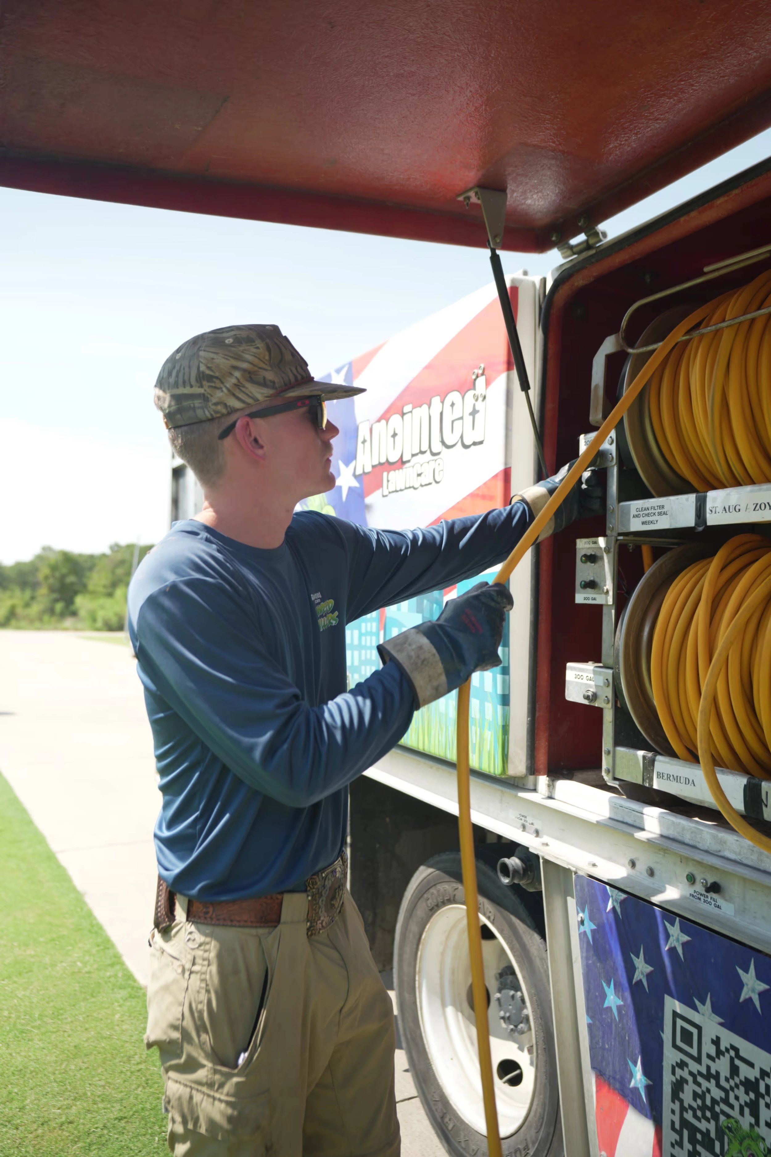 Man organizing yellow hoses on a truck.