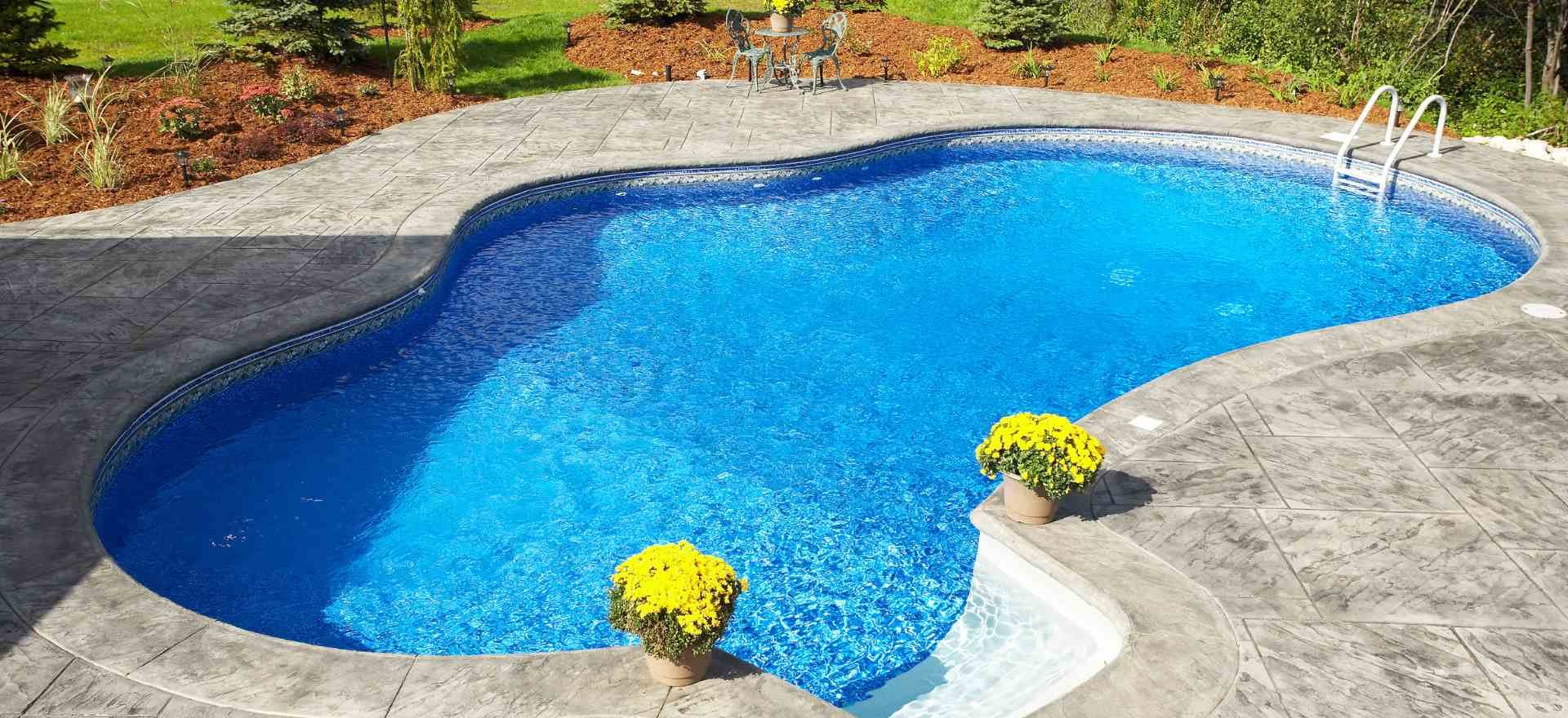 Beautiful oval swimming pool with vibrant blue water and flowers