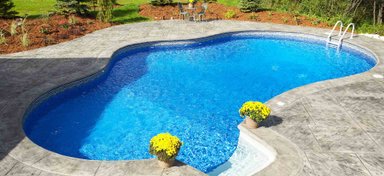 Beautiful oval swimming pool with vibrant blue water and flowers