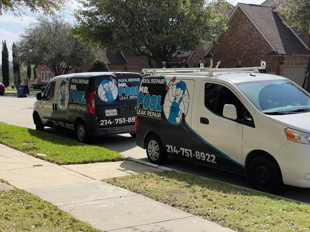 Two pool repair vans parked on a suburban street.