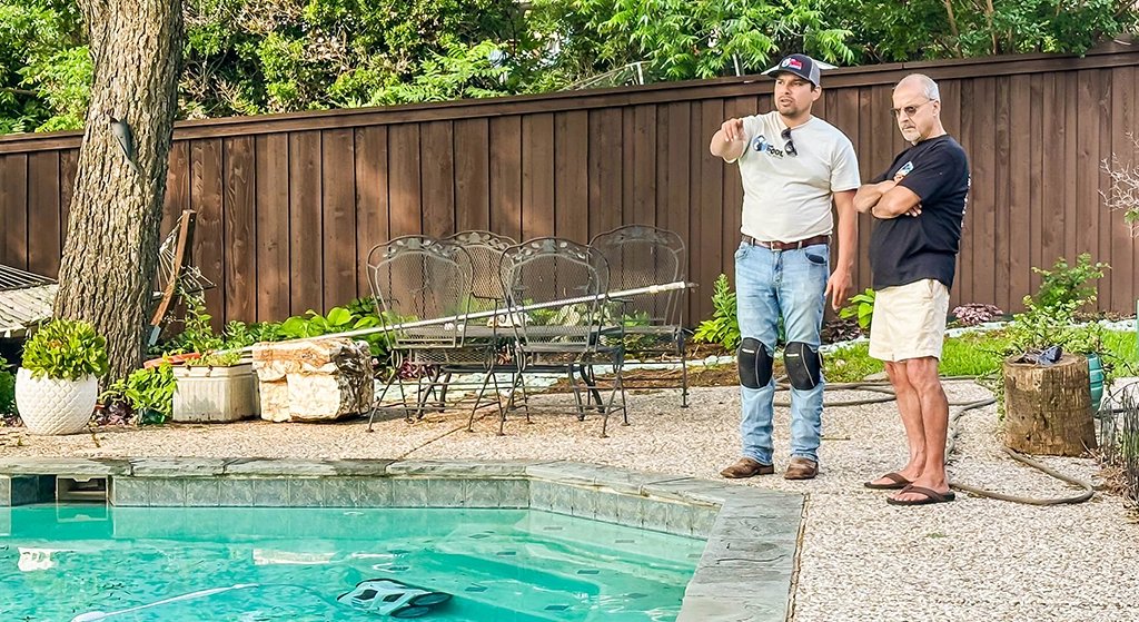 two men discussing pool maintenance beside a swimming pool
