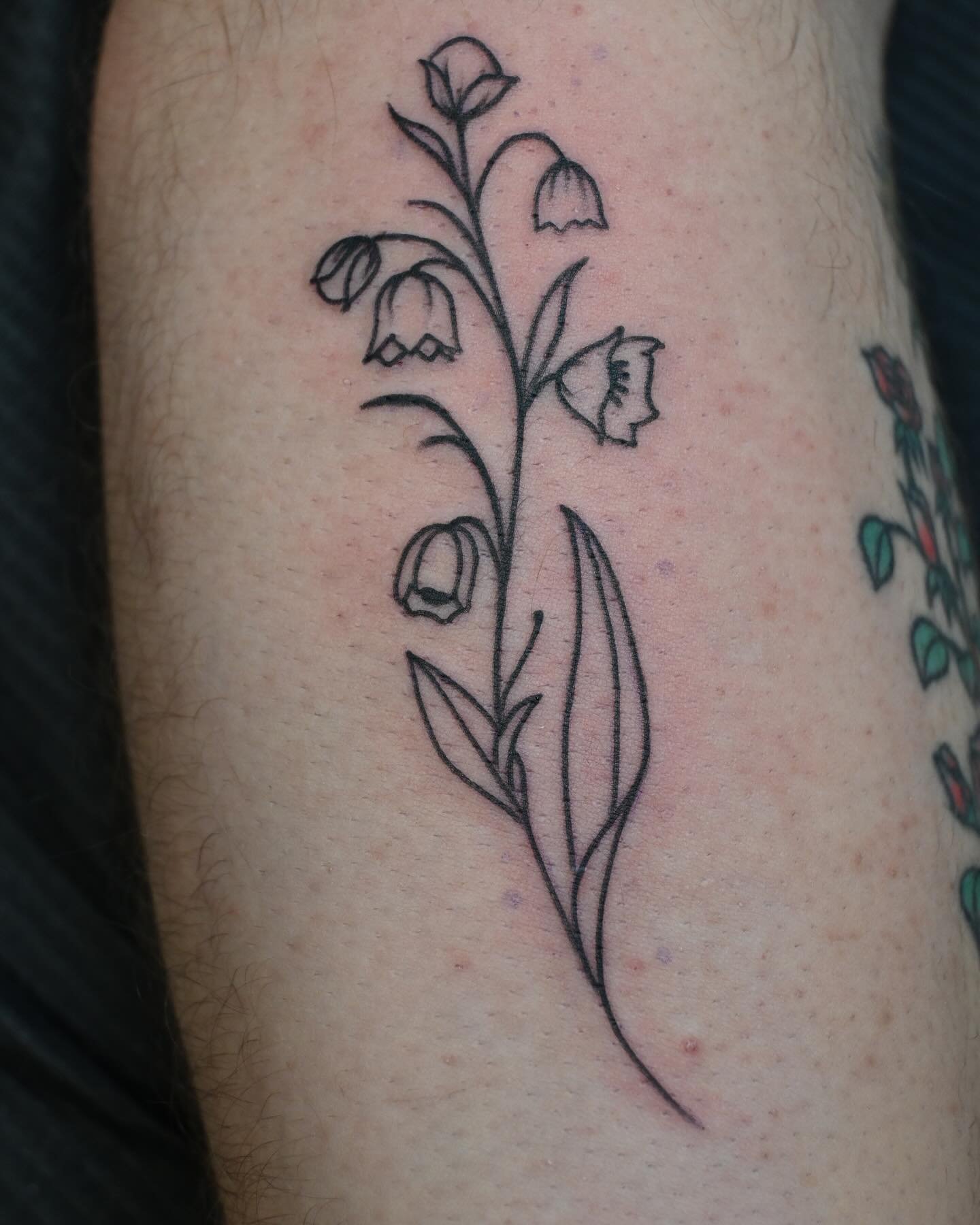 Delicate line art tattoo of flowers on skin