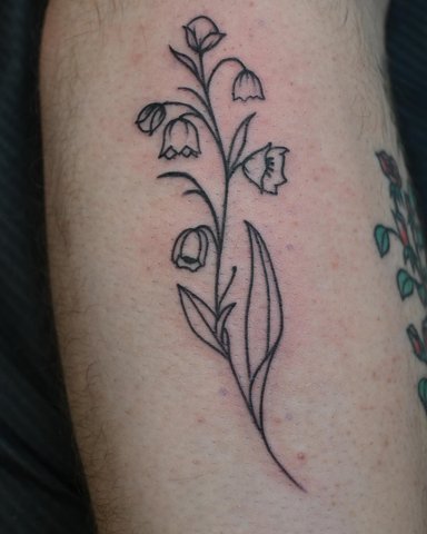 Delicate line art tattoo of flowers on skin