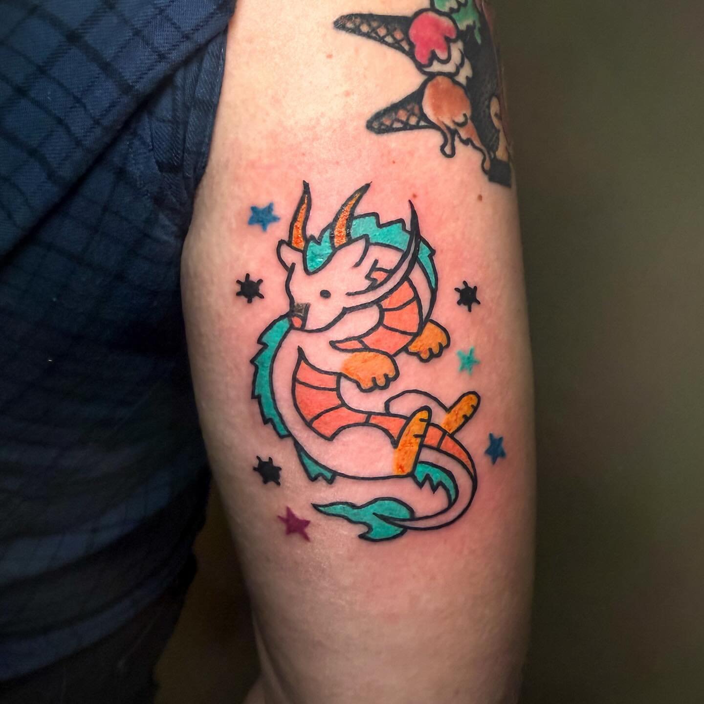 Colorful dragon tattoo on a person's arm.