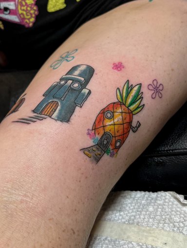 Colorful tattoo of cartoon characters on skin
