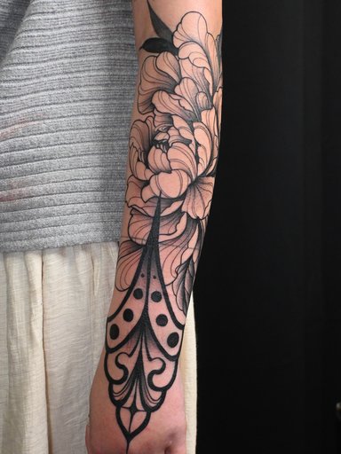 A detailed floral tattoo on a woman's forearm