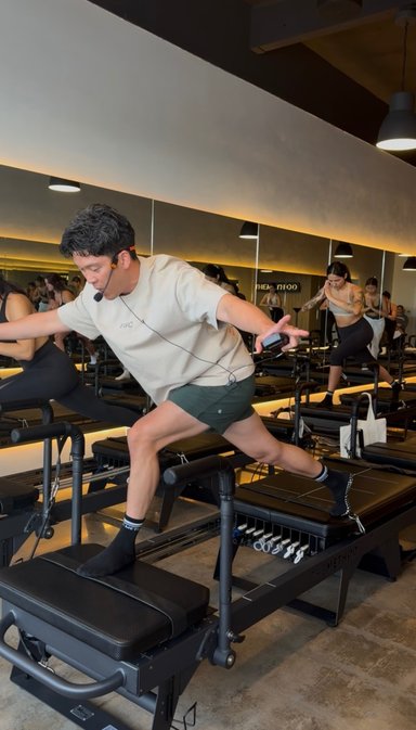 Person performing reformer Pilates exercise in a studio