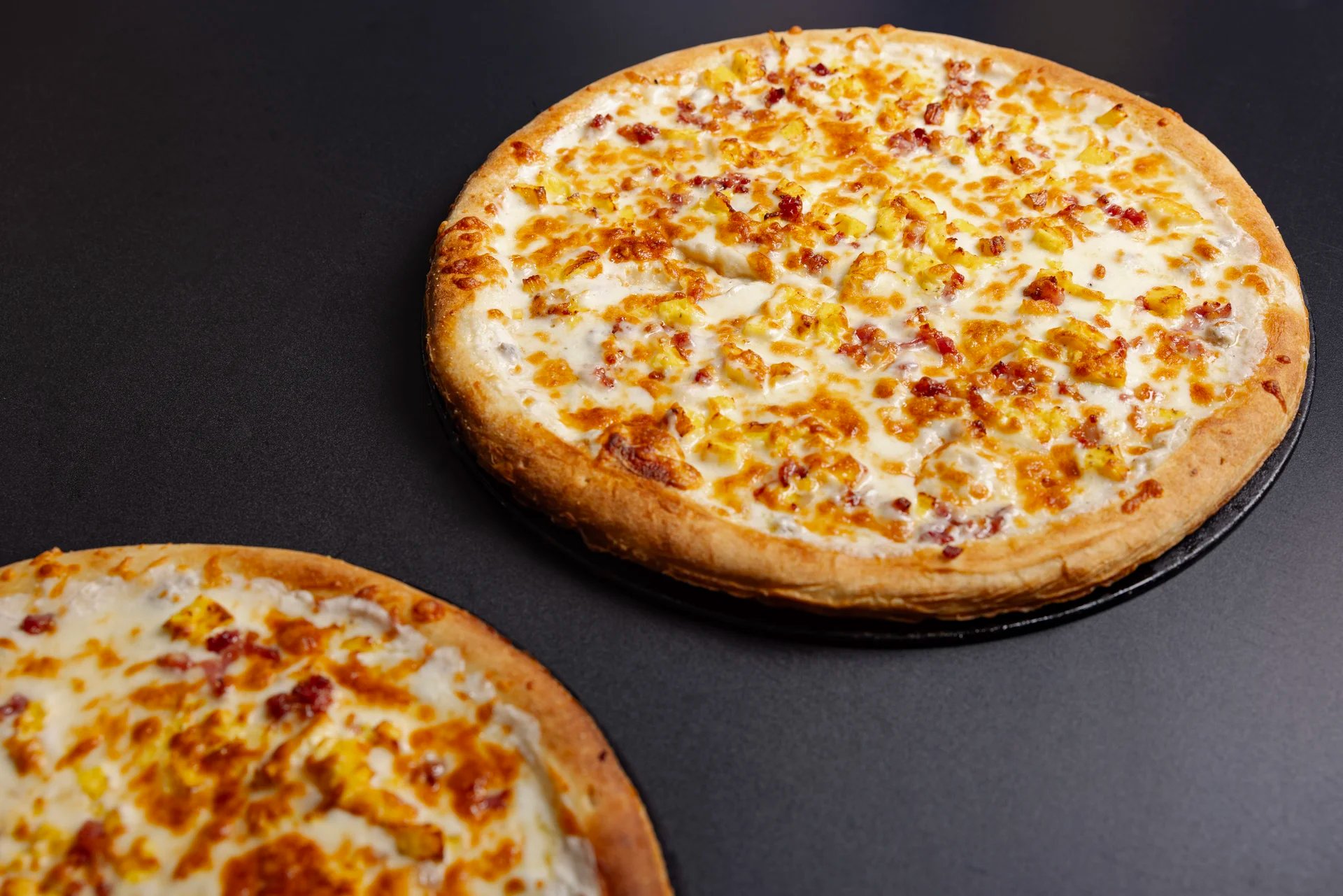 Two delicious pizzas with golden crusts and toppings.