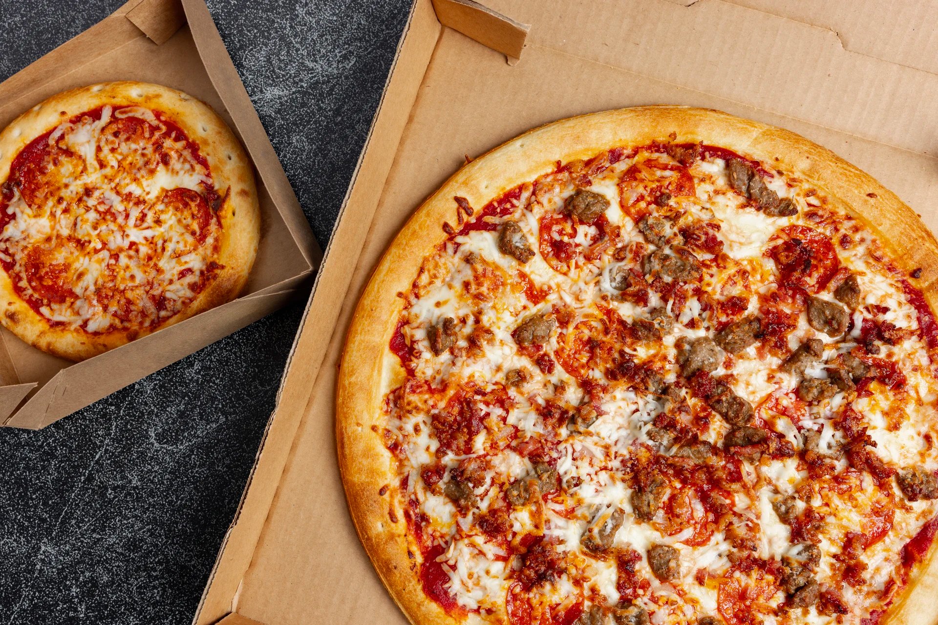 Delicious pizza with sausage and cheese in a box