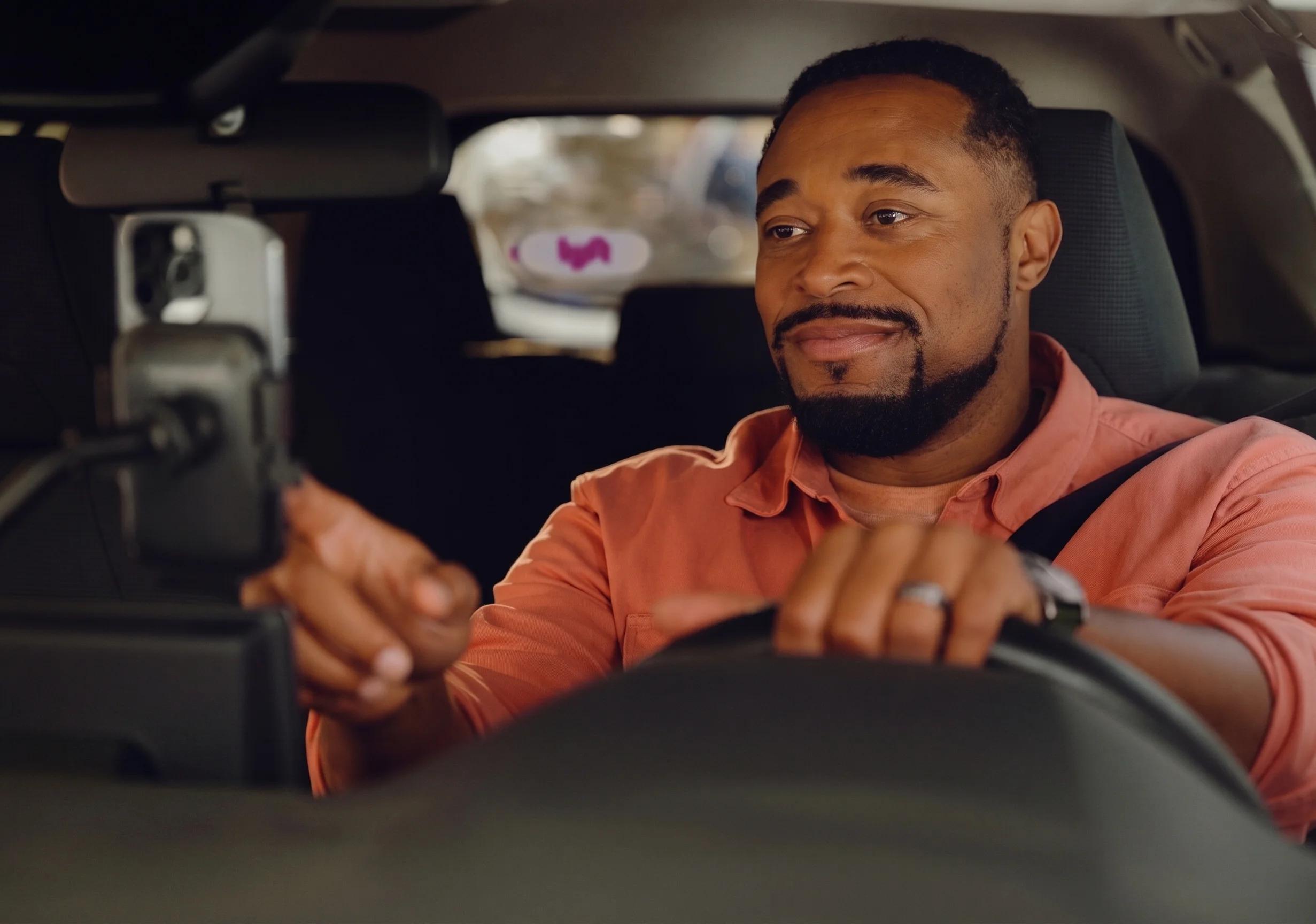 Man driving car and using mobile device