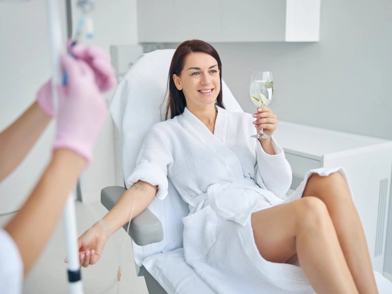 Woman receiving IV therapy with lemon water