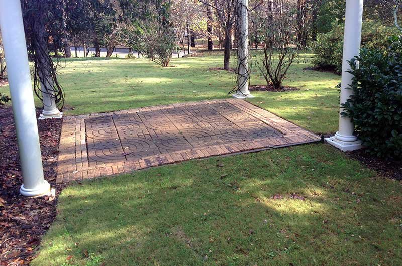 A landscaped garden with decorative paving and greenery.