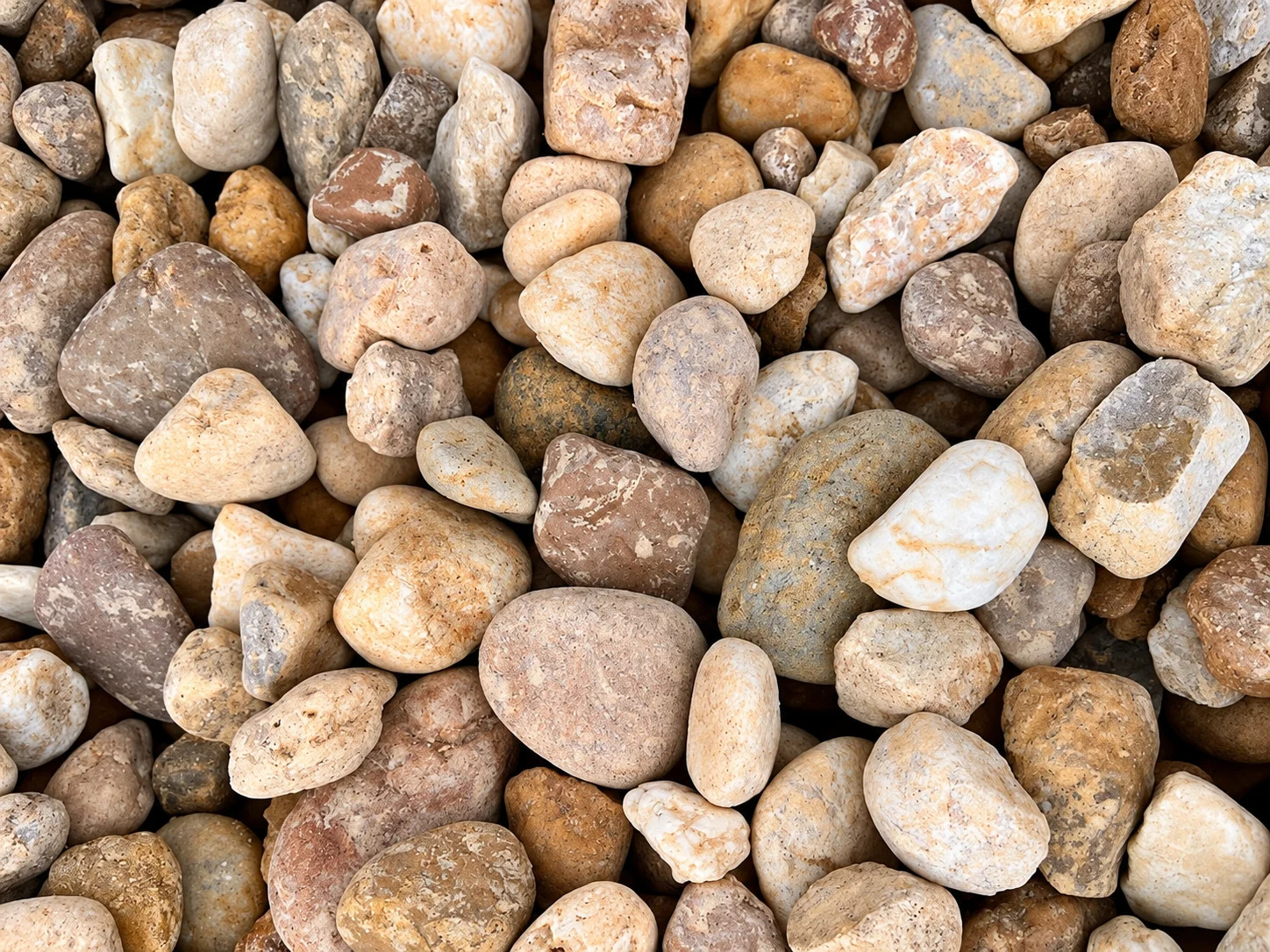 A collection of smooth, rounded stones in various shades of brown and beige