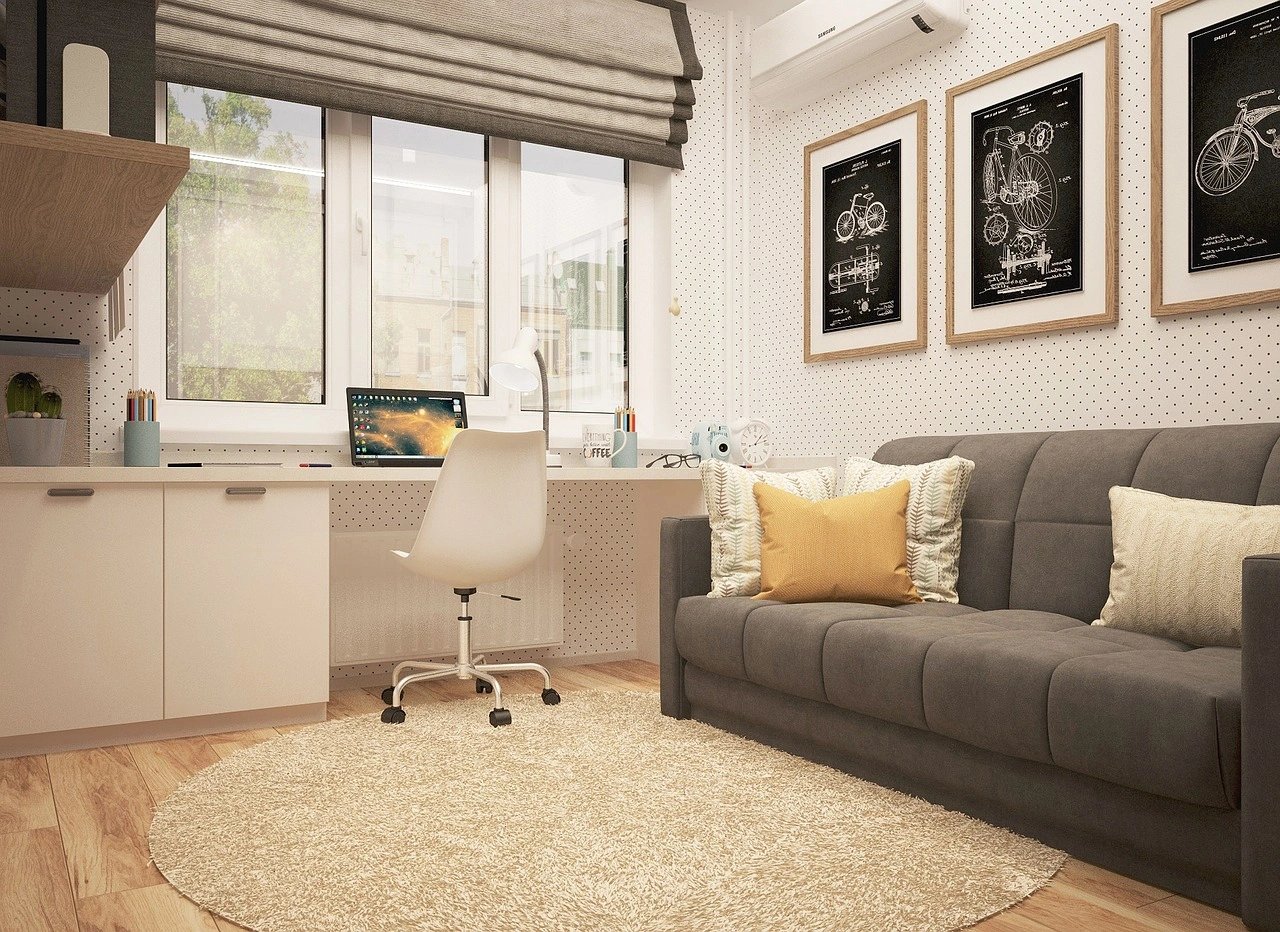Modern minimalist home office with grey couch and workspace