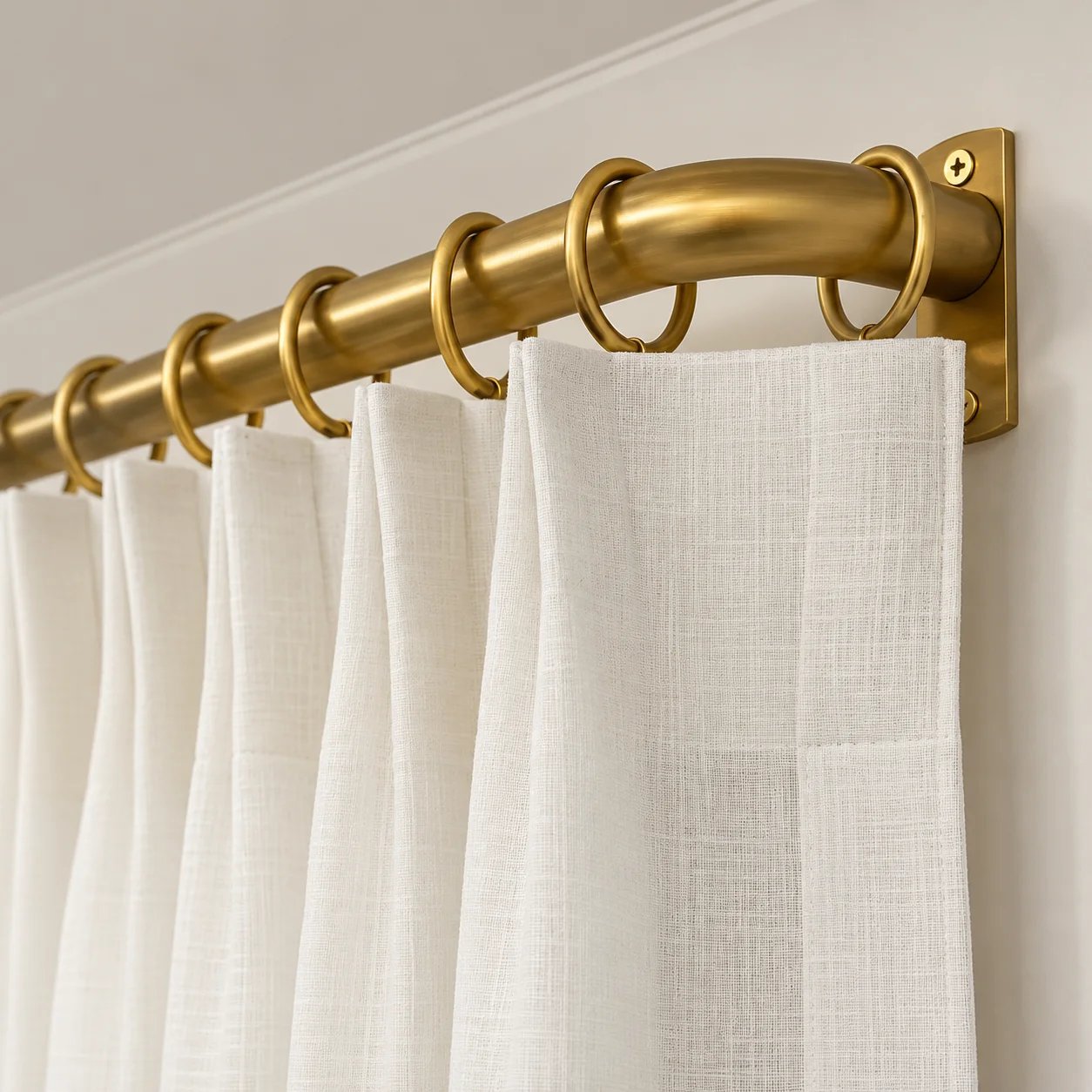 Elegant white sheer curtains on a gold rod