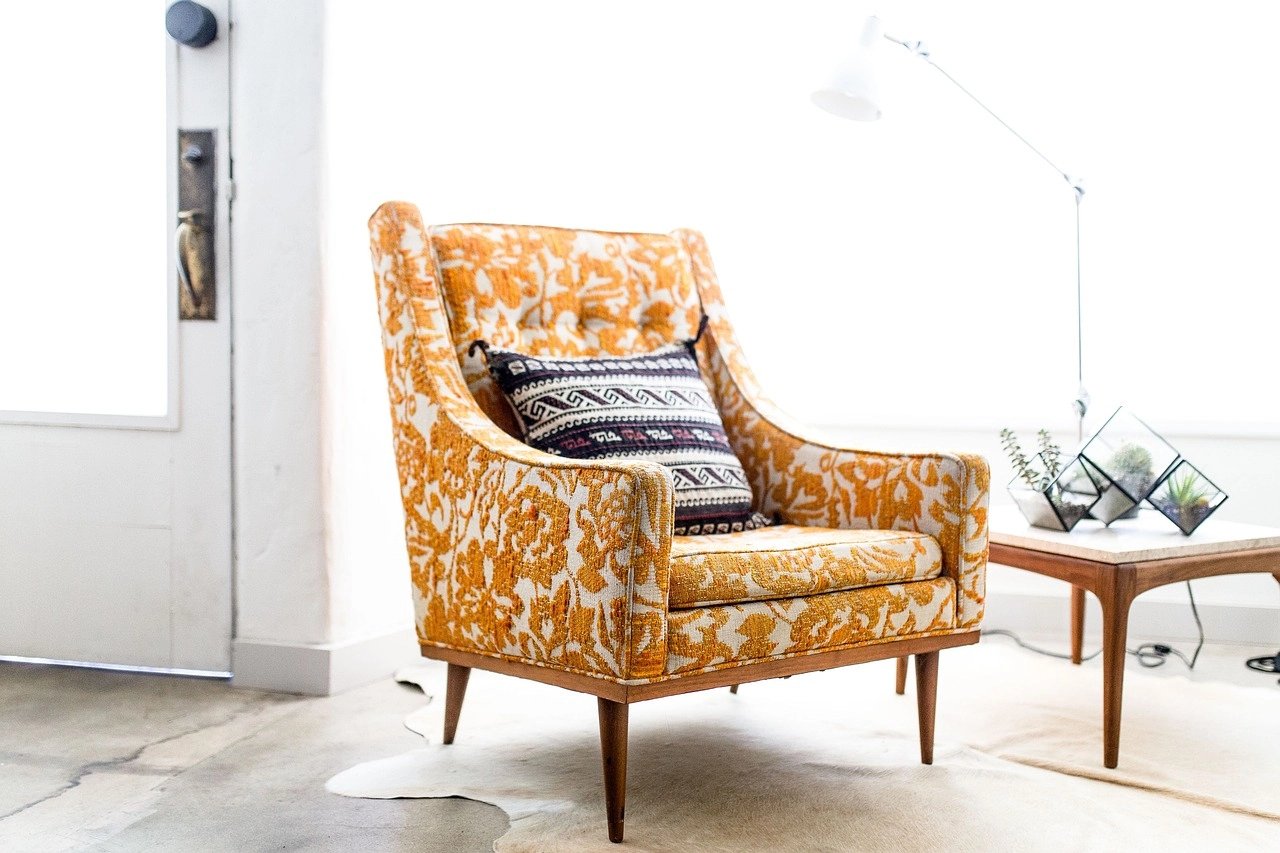 Cozy orange patterned armchair with decorative pillow