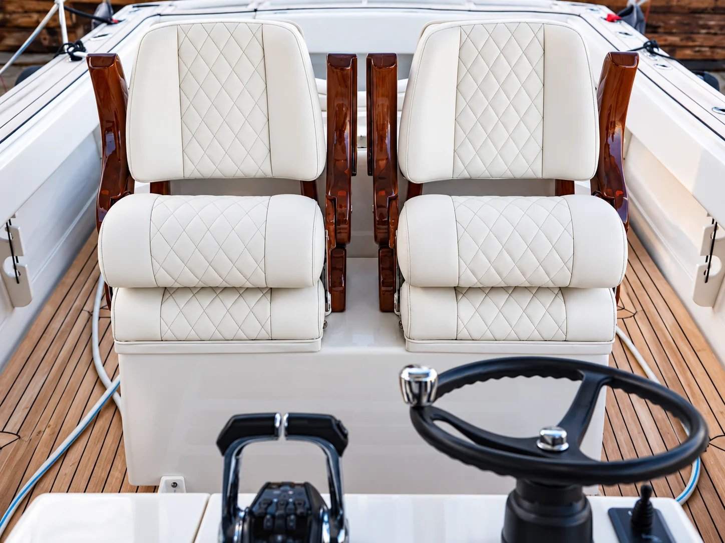 Elegant boat interior with plush white seats and steering wheel