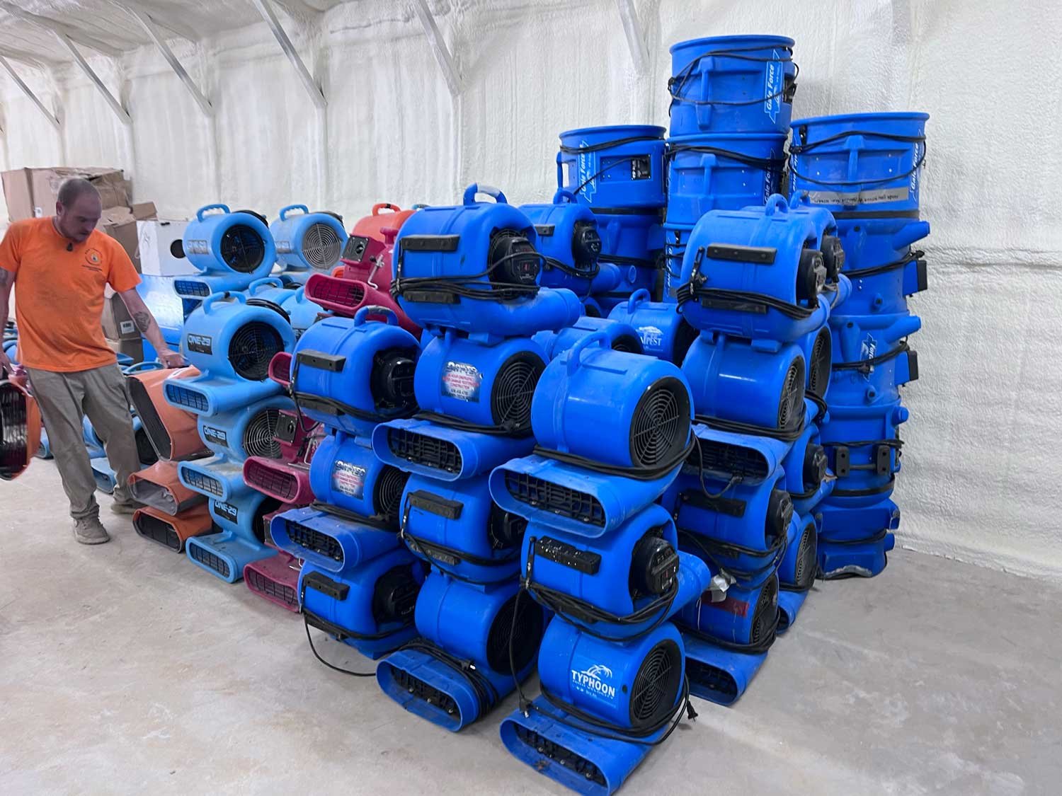 Blue air movers stacked in a warehouse setting