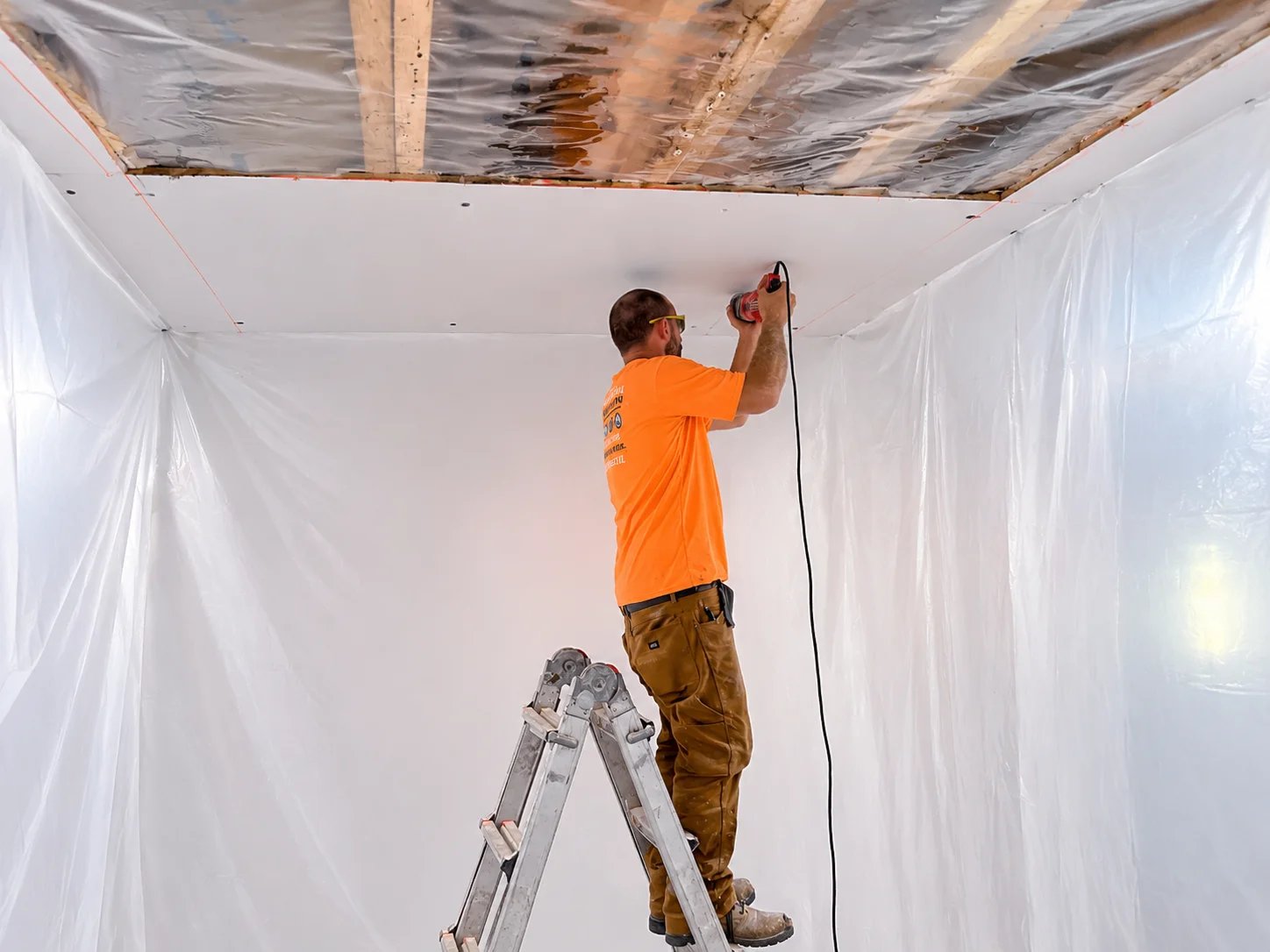 Man installing drywall in a construction area
