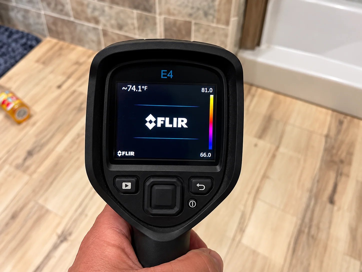 FLIR E4 thermal imaging camera displaying temperature readings.